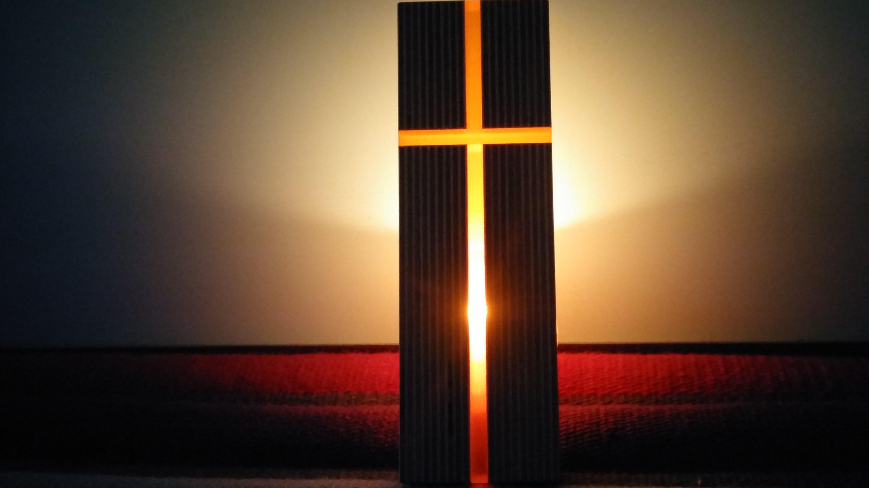 Lichtkreuz Ein Kreuz von hinten mit Kerzenlicht durchleuchtet
